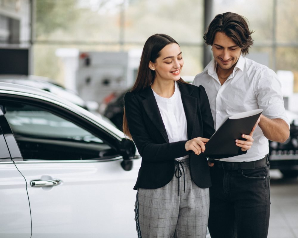 Woman choosing a car in a car showroom